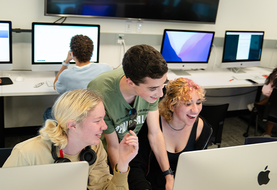 image of three summer pre-college students surrounding a computer