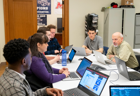 Image of students collaborating with a faculty member.