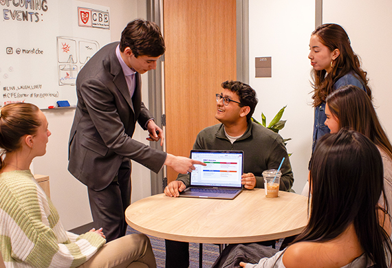 Image of Matt Poillucci ’28 points to his strategic business plan while collaborating with fellow SOM students. Photo by Alyssa Walrad/Marist University.