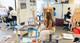 image of students working at canvas easels 