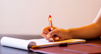 Image of a pen writing on paper.