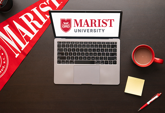 image of computer on tabletop with Marist University items.