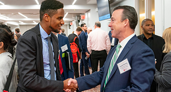 image of a student shaking a man's hand