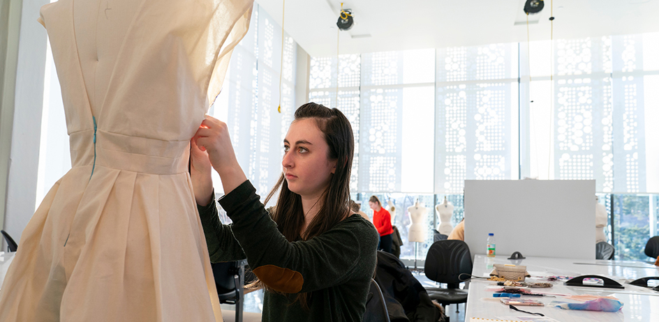 Photo of student pinning clothes on mannequin