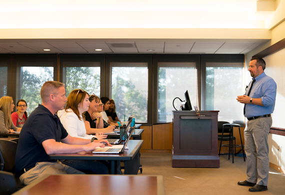 Image of adult students in classroom discussion with faculty