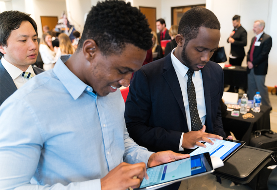 An image of students attending a career fair networking with an employer.