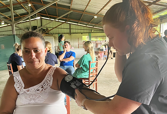 Image of Jenna Jedlicka ’25 on the Costa Rica mission working with a patient.