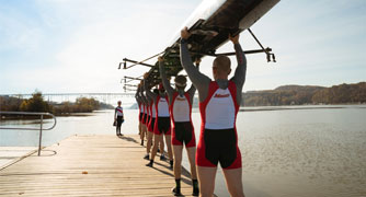 Image of the rowing team holding a crew shell.