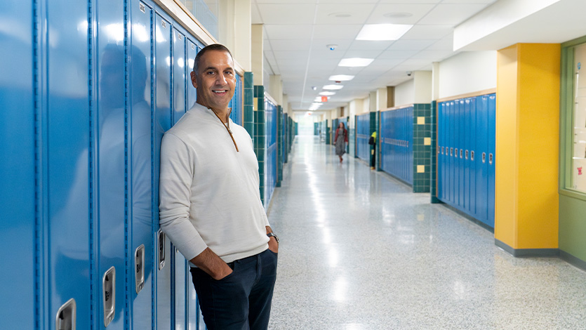 Image of John Liporace '88 by his old locker at Hoosick Falls High School in 2023.