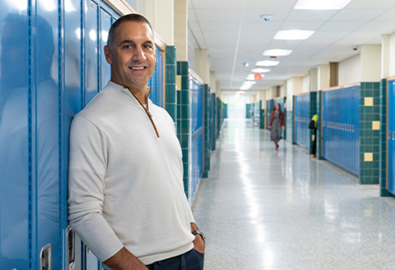 Image of John Liporace '88 by his old locker at Hoosick Falls High School in 2023.