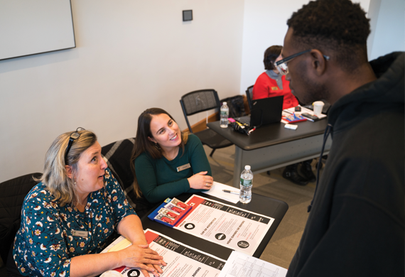 Image of student speaking with Student Financial Services staff at an on-campus program.