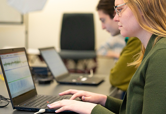 Image of a students on computers monitoring brain activity