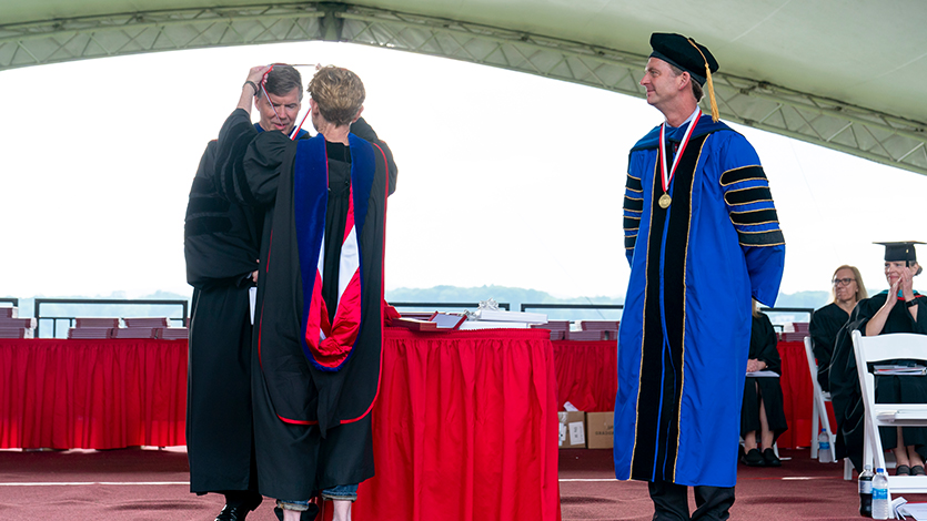 image of Ian O’Connor ’86 (left) receives the Distinguished Alumni Medal from Eileen Gilfedder Altobelli ’82, President of the Alumni Association (center) as Marist College President Dr. Kevin Weinman (right) looks on.