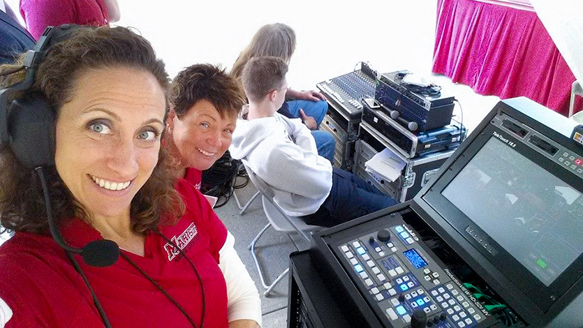 Joey Wall (left) and Lisa Hamel (right) from the Media Center behind the scenes at a commencement ceremony