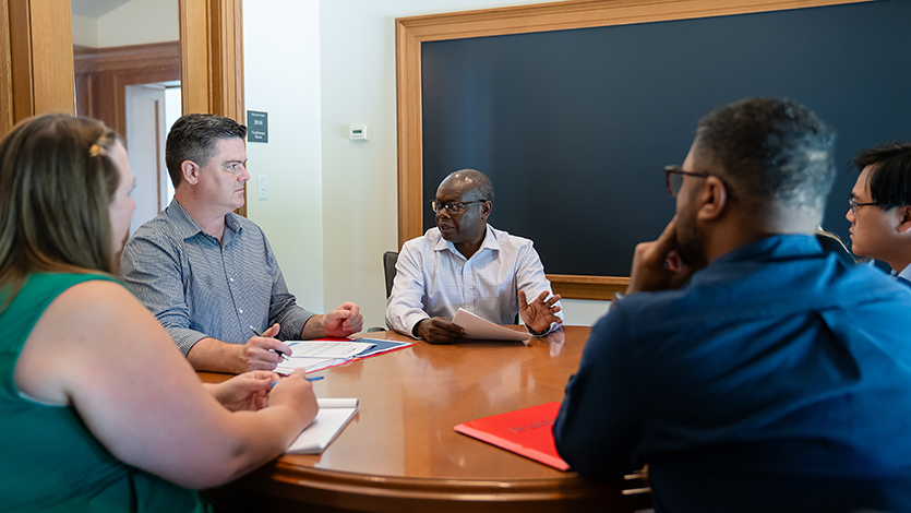 Image of Dr. Antonio with colleagues discussing interfaith project.