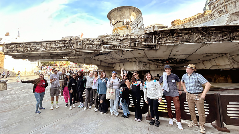 Image of the class standing in front of the Millennium Falcon from Star Wars. 