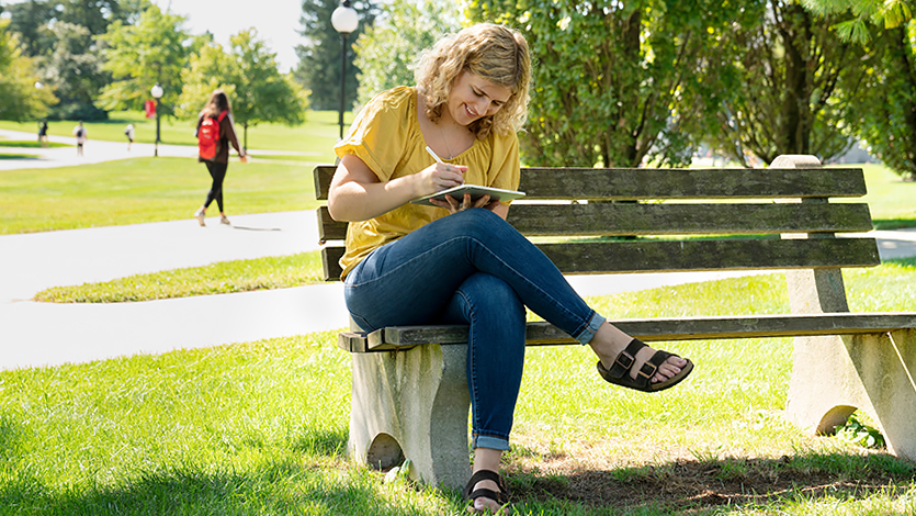 Image of student working outside on a sunny day.