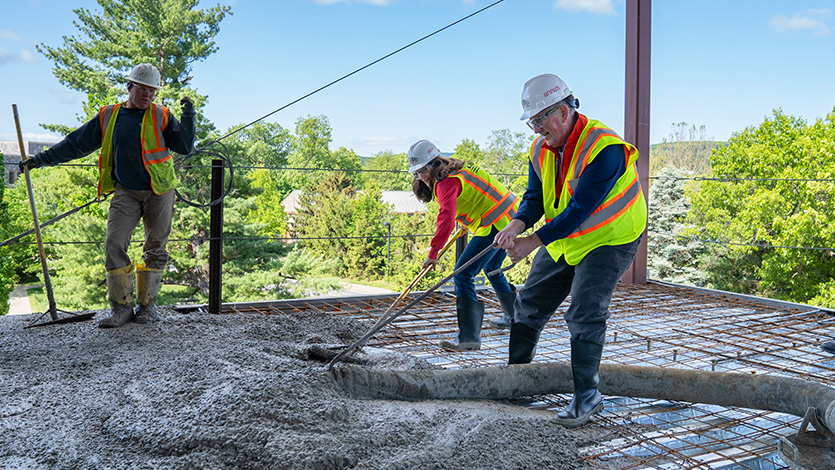 Dean Lamb (center) laying concrete in Dyson Center office spaces beside Dean Gatins. Photo by Zach Gawron/Marist College. 