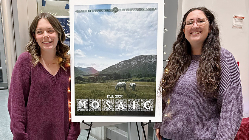 Image of Abby Castonguay and Riley Mazzocco posing with the cover of the Mosaic at the Fall 2024 launch party.