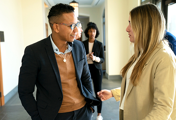 Admitted student speaking with a faculty member at Dinner with the Deans