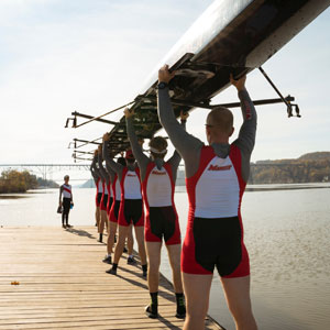 Image of the rowing team holding a crew shell.